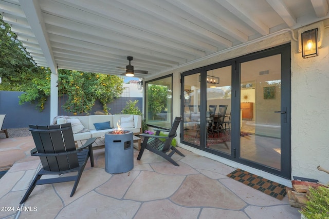 view of patio with ceiling fan and an outdoor living space with a fire pit