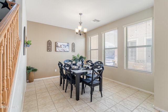 tiled dining room featuring a chandelier