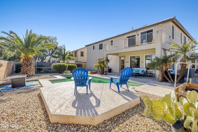 exterior space featuring a swimming pool, outdoor lounge area, a patio area, and a trampoline