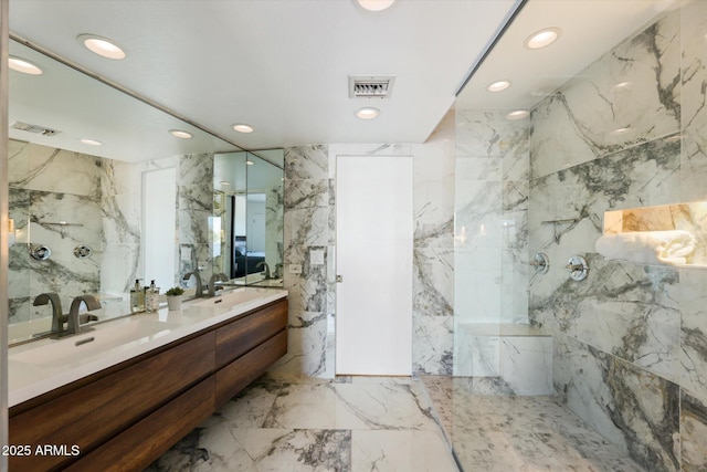 bathroom featuring walk in shower, vanity, and tile walls