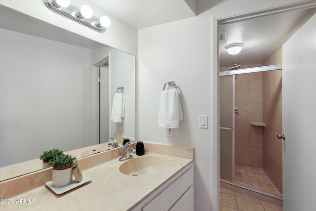 bathroom featuring tile patterned floors, a shower with shower door, and vanity