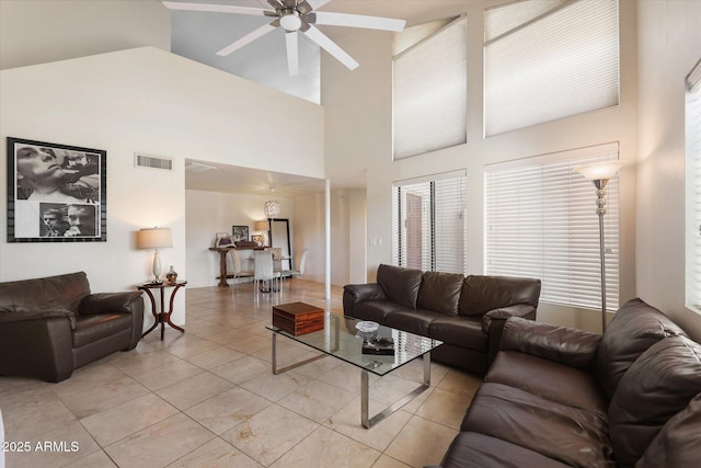 tiled living room featuring ceiling fan and high vaulted ceiling