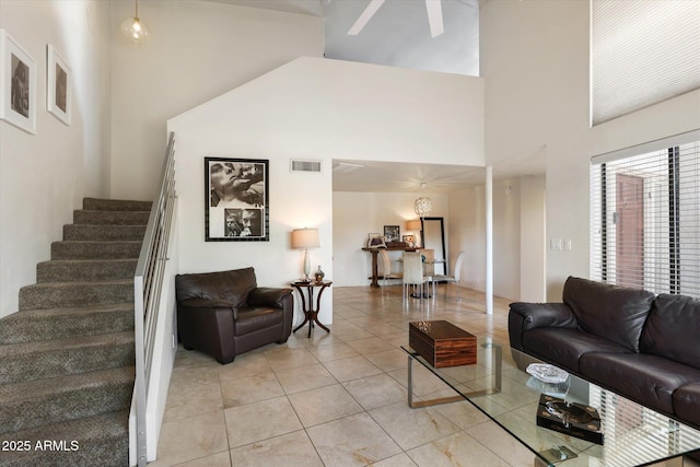 living room with a towering ceiling and light tile patterned flooring