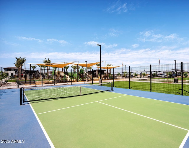 view of tennis court with playground community and fence