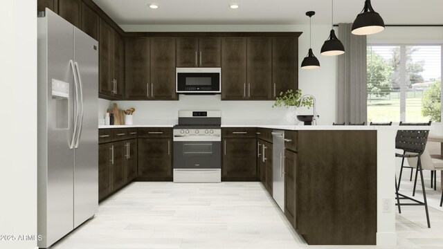 kitchen with dark brown cabinets, appliances with stainless steel finishes, a peninsula, and light countertops