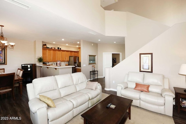 living room featuring wood finished floors, visible vents, baseboards, an inviting chandelier, and recessed lighting