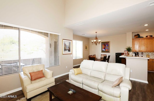 living room featuring a notable chandelier, recessed lighting, dark wood-type flooring, and baseboards