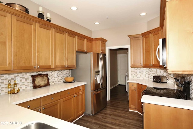 kitchen with white microwave, dark wood-style floors, stainless steel fridge, and light countertops