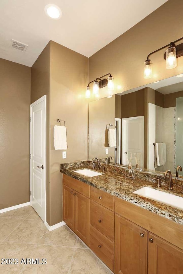 bathroom featuring double vanity, visible vents, tile patterned floors, and a sink