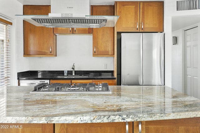 kitchen featuring sink, stainless steel appliances, range hood, and light stone countertops