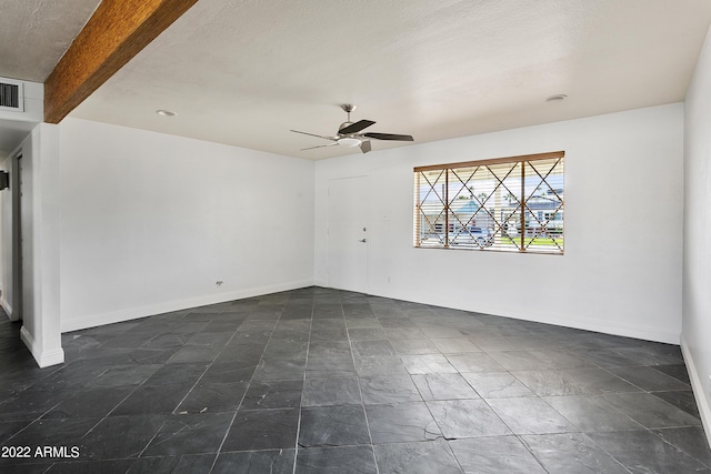 empty room featuring beam ceiling and ceiling fan