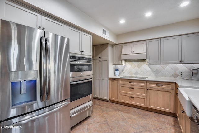 kitchen featuring tasteful backsplash, stainless steel appliances, and light tile patterned flooring