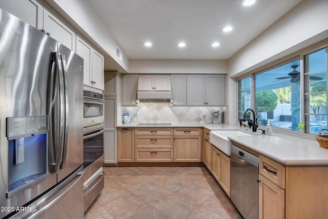 kitchen featuring sink, light tile patterned floors, stainless steel appliances, tasteful backsplash, and light brown cabinetry