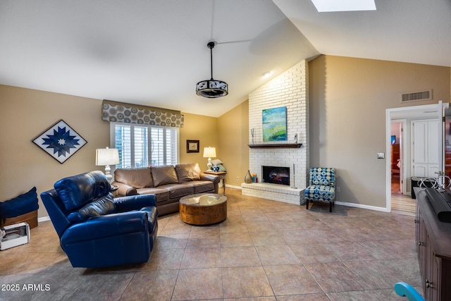 tiled living room with vaulted ceiling with skylight and a brick fireplace