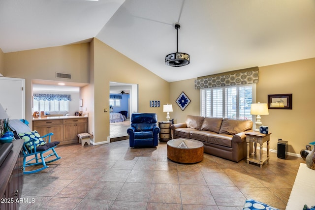 tiled living room with high vaulted ceiling and ceiling fan