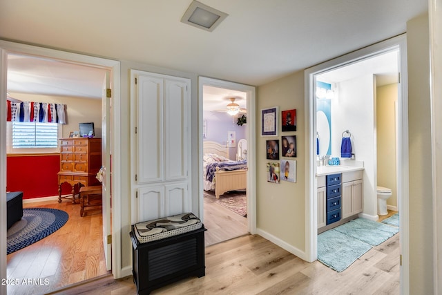 corridor featuring sink and light hardwood / wood-style floors