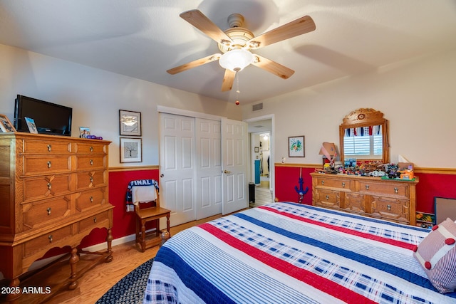 bedroom featuring hardwood / wood-style flooring, ceiling fan, and a closet