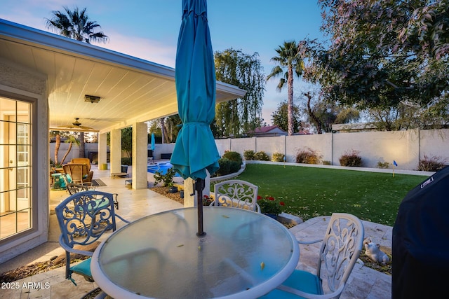 patio terrace at dusk with a yard and a grill