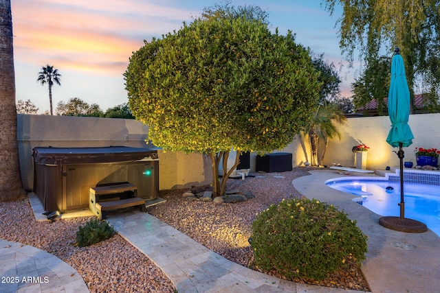 exterior space featuring a swimming pool with hot tub and a patio area