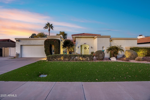 view of front of property featuring a garage and a lawn