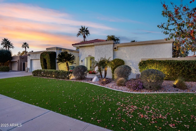 view of front of home with a garage and a yard