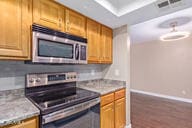 kitchen with dark hardwood / wood-style flooring and stainless steel appliances