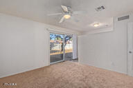 empty room featuring ceiling fan and carpet floors