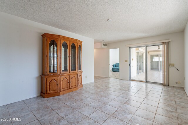 10335 W Mission Ln, Sun City, AZ 85351 - spare room featuring light tile patterned floors, visible vents, baseboards, and a textured ceiling