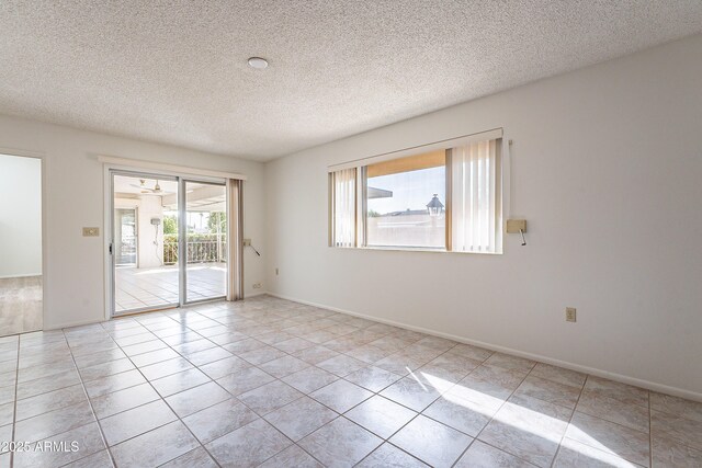 10335 W Mission Ln, Sun City, AZ 85351 - empty room featuring light tile patterned floors, a textured ceiling, and baseboards