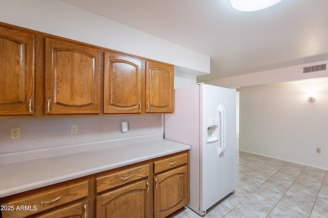 10335 W Mission Ln, Sun City, AZ 85351 - kitchen featuring light countertops, white refrigerator with ice dispenser, visible vents, and brown cabinets