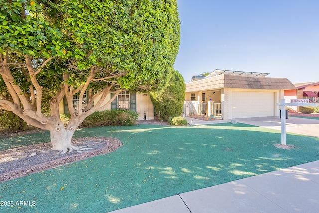 10335 W Mission Ln, Sun City, AZ 85351 - view of front of property featuring fence, mansard roof, an attached garage, concrete driveway, and brick siding
