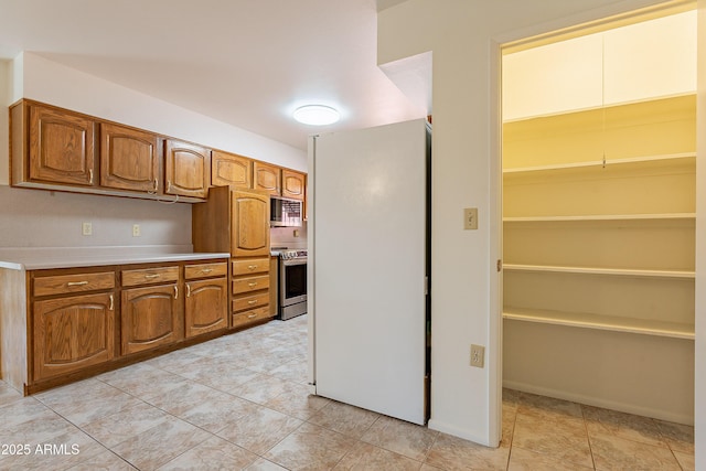 10335 W Mission Ln, Sun City, AZ 85351 - kitchen with brown cabinets, stainless steel appliances, and light countertops