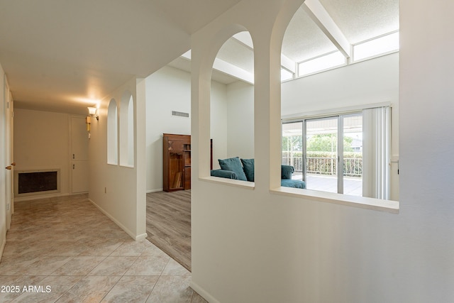10335 W Mission Ln, Sun City, AZ 85351 - corridor with visible vents, light tile patterned floors, baseboards, and arched walkways