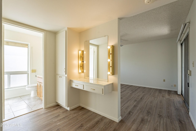 10335 W Mission Ln, Sun City, AZ 85351 - corridor featuring wood finished floors, baseboards, and a textured ceiling