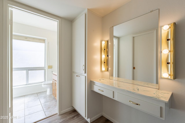 10335 W Mission Ln, Sun City, AZ 85351 - bathroom featuring tile patterned floors, baseboards, toilet, and vanity