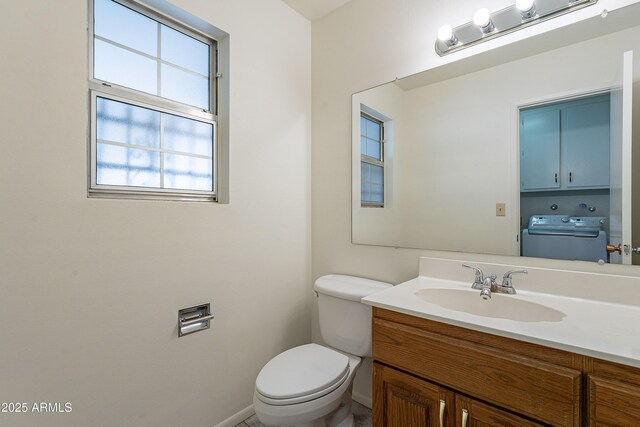10335 W Mission Ln, Sun City, AZ 85351 - bathroom featuring toilet, washer / clothes dryer, vanity, and baseboards