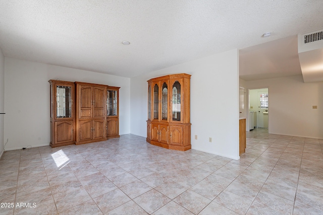 10335 W Mission Ln, Sun City, AZ 85351 - empty room with light tile patterned floors, visible vents, and a textured ceiling