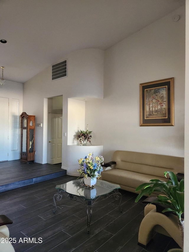 living room featuring lofted ceiling and dark hardwood / wood-style flooring