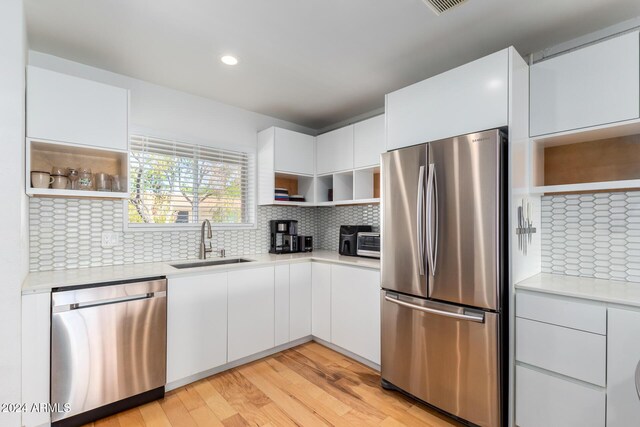 4701 N 68th St Unit 144, Scottsdale, AZ 85251 - kitchen with stainless steel appliances, open shelves, a sink, light countertops, and light wood-style flooring