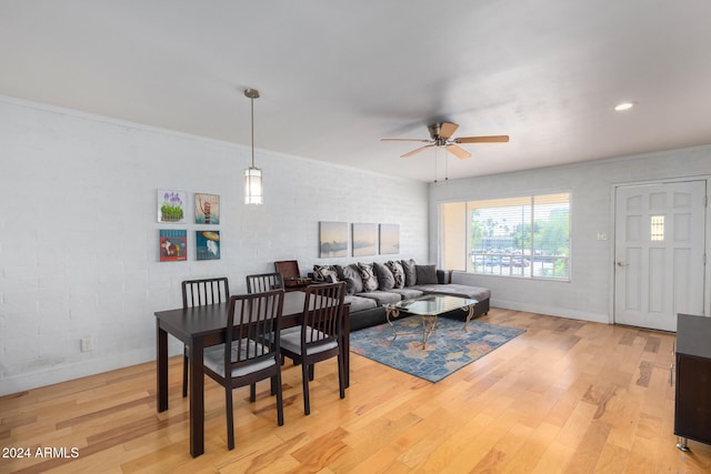 dining area with ceiling fan, light wood-type flooring, and ornamental molding