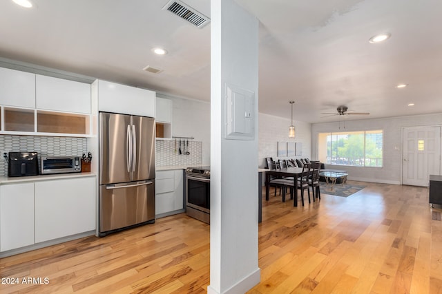 kitchen featuring stainless steel appliances, light hardwood / wood-style floors, white cabinetry, ceiling fan, and backsplash