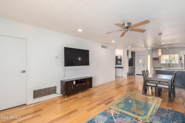 living room featuring light hardwood / wood-style floors and ceiling fan