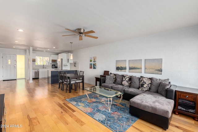 living room with ceiling fan and light hardwood / wood-style flooring