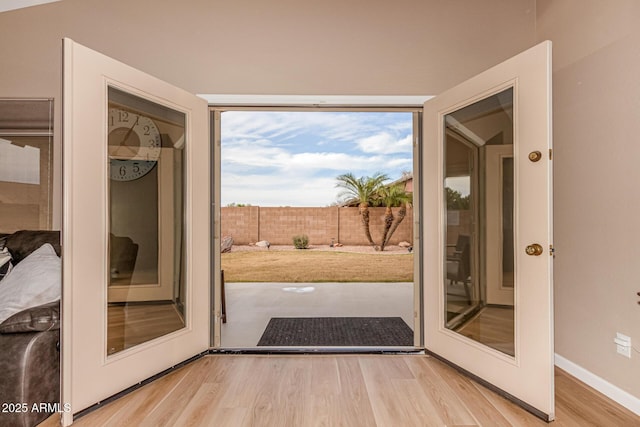 doorway to outside featuring light wood-style flooring and baseboards