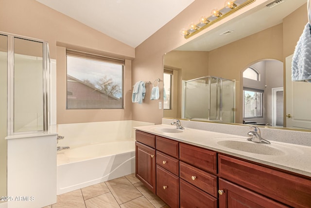 bathroom featuring lofted ceiling, a garden tub, a sink, and a stall shower