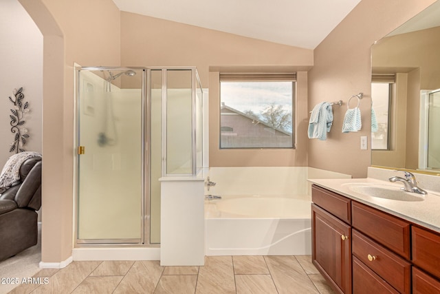 bathroom featuring a stall shower, lofted ceiling, a garden tub, and vanity