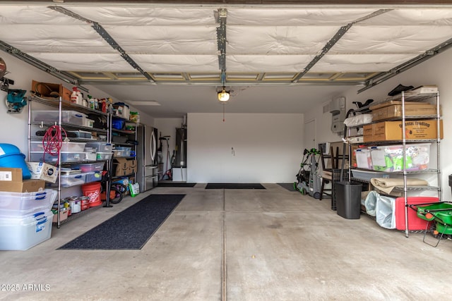 garage featuring water heater and freestanding refrigerator