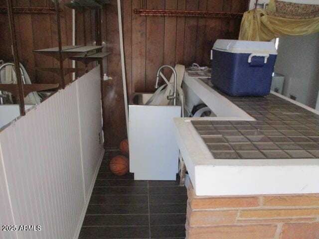 laundry area with wood walls