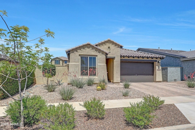 mediterranean / spanish-style home featuring concrete driveway, an attached garage, a tile roof, and stucco siding
