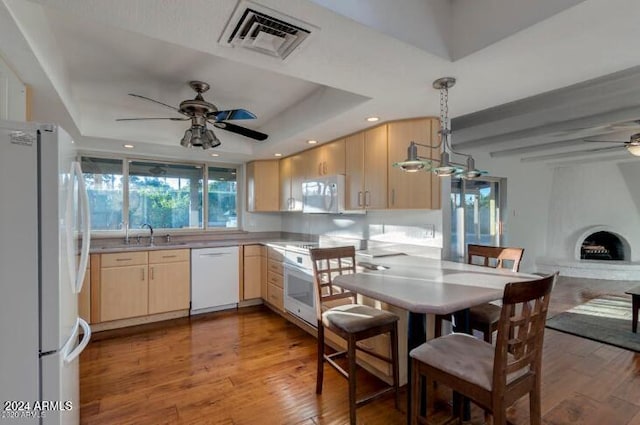 kitchen with ceiling fan, light brown cabinets, white appliances, and a tray ceiling